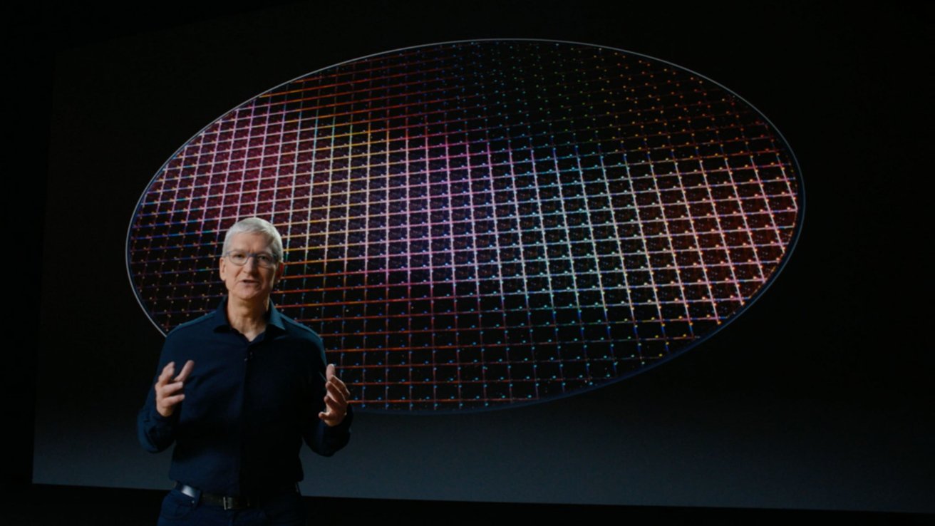 A person stands in front of a large circular grid with colorful reflections on a dark background.